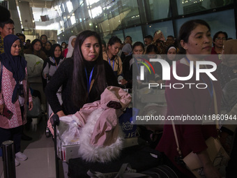 Indonesian citizens (WNI) walk out of the arrivals terminal shortly after arriving from Syria at Soekarno-Hatta Airport in Tangerang, Banten...