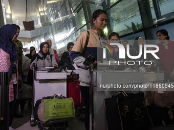 Indonesian citizens (WNI) walk out of the arrivals terminal shortly after arriving from Syria at Soekarno-Hatta Airport in Tangerang, Banten...