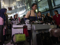 Indonesian citizens (WNI) walk out of the arrivals terminal shortly after arriving from Syria at Soekarno-Hatta Airport in Tangerang, Banten...