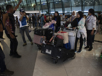 Indonesian citizens (WNI) walk out of the arrivals terminal shortly after arriving from Syria at Soekarno-Hatta Airport in Tangerang, Banten...