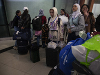 Indonesian citizens (WNI) walk out of the arrivals terminal shortly after arriving from Syria at Soekarno-Hatta Airport in Tangerang, Banten...