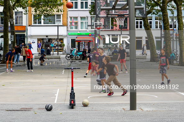 A lively basketball court in Antwerp, Belgium, on August 1, 2023, bustles with energy as teenagers and young adults engage in friendly match...