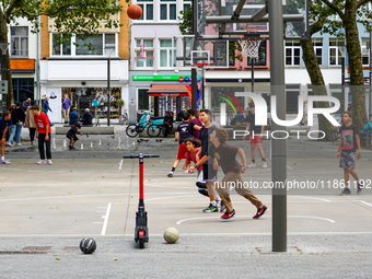 A lively basketball court in Antwerp, Belgium, on August 1, 2023, bustles with energy as teenagers and young adults engage in friendly match...