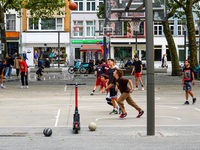 A lively basketball court in Antwerp, Belgium, on August 1, 2023, bustles with energy as teenagers and young adults engage in friendly match...