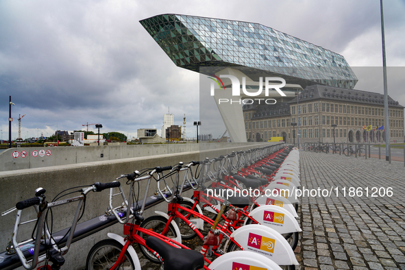 A row of Velo Antwerp rental bicycles is stationed near the Port House in Antwerp, Belgium, on July 31, 2023. The glass-and-steel architectu...