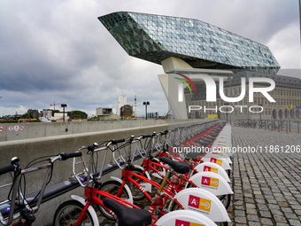 A row of Velo Antwerp rental bicycles is stationed near the Port House in Antwerp, Belgium, on July 31, 2023. The glass-and-steel architectu...