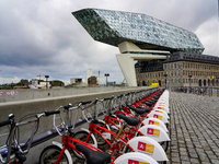 A row of Velo Antwerp rental bicycles is stationed near the Port House in Antwerp, Belgium, on July 31, 2023. The glass-and-steel architectu...