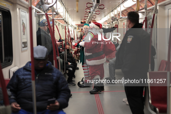 A person dressed as Santa Claus distributes candy canes in the TTC subway in Toronto, Canada, on December 11, 2024. 