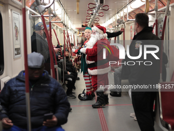 A person dressed as Santa Claus distributes candy canes in the TTC subway in Toronto, Canada, on December 11, 2024. (