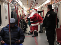 A person dressed as Santa Claus distributes candy canes in the TTC subway in Toronto, Canada, on December 11, 2024. (