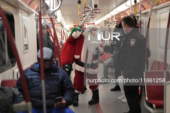 A person dressed as Santa Claus distributes candy canes in the TTC subway in Toronto, Canada, on December 11, 2024. 