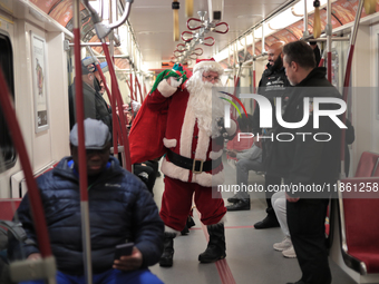 A person dressed as Santa Claus distributes candy canes in the TTC subway in Toronto, Canada, on December 11, 2024. (