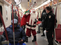 A person dressed as Santa Claus distributes candy canes in the TTC subway in Toronto, Canada, on December 11, 2024. (