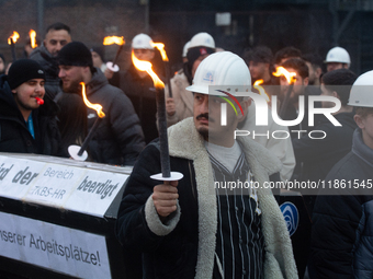 One hundred Thyssenkrupp Europe Steel workers march against planned job cuts before heading to the Works Council meeting in Duisburg, German...