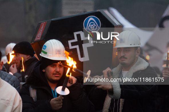 A hundred Thyssenkrupp Europe Steel workers march with a coffin against planned job cuts before heading to the Works Council meeting in Duis...