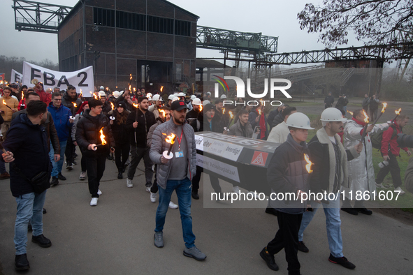 A hundred Thyssenkrupp Europe Steel workers march with a coffin against planned job cuts before heading to the Works Council meeting in Duis...