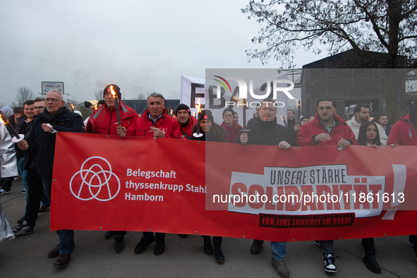 A hundred Thyssenkrupp Europe Steel workers march with a coffin against planned job cuts before heading to the Works Council meeting in Duis...