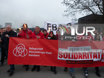 A hundred Thyssenkrupp Europe Steel workers march with a coffin against planned job cuts before heading to the Works Council meeting in Duis...