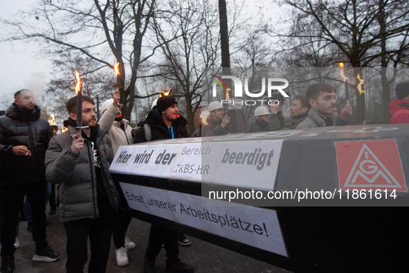 A hundred Thyssenkrupp Europe Steel workers march with a coffin against planned job cuts before heading to the Works Council meeting in Duis...