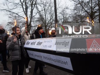 A hundred Thyssenkrupp Europe Steel workers march with a coffin against planned job cuts before heading to the Works Council meeting in Duis...