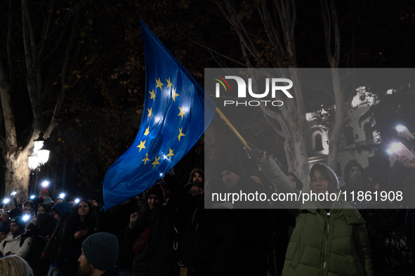 An anti-government protester waves a European Union flag during a demonstration against the Georgian government's postponement of European U...