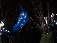 An anti-government protester waves a European Union flag during a demonstration against the Georgian government's postponement of European U...