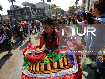 A woman dressed in a folkloric dress takes part in a dance during the celebrations of the Day of the Virgin of Guadalupe in Mexico City, Mex...