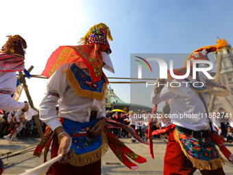 People dressed in folk costumes take part in a dance during the celebrations of the Day of the Virgin of Guadalupe in Mexico City, Mexico, o...