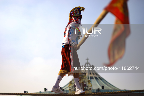 A person dressed in a folk costume takes part in a dance during the celebrations of the Day of the Virgin of Guadalupe in Mexico City, Mexic...