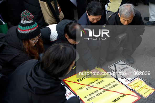 Members of the Korean Confederation of Trade Unions (KCTU) and other civil society groups attach a ''Notice of Eviction'' on the road in fro...