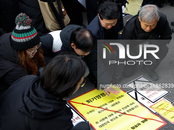 Members of the Korean Confederation of Trade Unions (KCTU) and other civil society groups attach a ''Notice of Eviction'' on the road in fro...