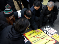 Members of the Korean Confederation of Trade Unions (KCTU) and other civil society groups attach a ''Notice of Eviction'' on the road in fro...