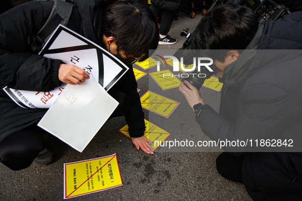 Members of the Korean Confederation of Trade Unions (KCTU) and other civil society groups attach a ''Notice of Eviction'' on the road in fro...