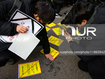 Members of the Korean Confederation of Trade Unions (KCTU) and other civil society groups attach a ''Notice of Eviction'' on the road in fro...