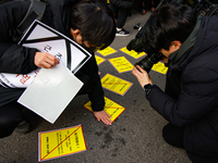 Members of the Korean Confederation of Trade Unions (KCTU) and other civil society groups attach a ''Notice of Eviction'' on the road in fro...