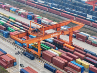 Cranes load import and export cargo containers at the Nanchang International Land Port Freight Yard cargo yard in Nanchang, Jiangxi province...