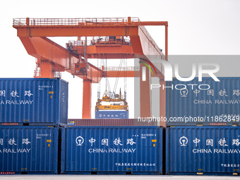 Cranes load import and export cargo containers at the Nanchang International Land Port Freight Yard cargo yard in Nanchang, Jiangxi province...