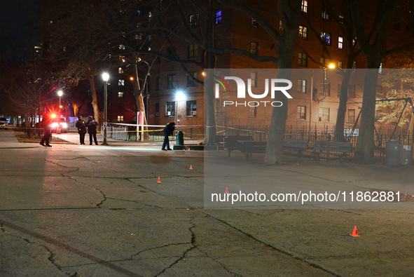 The NYPD evidence collection team gathers evidence and marks shell casings at the scene where two people are shot at Lafayette Gardens NYCHA...