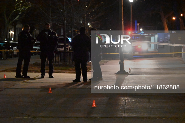 The NYPD evidence collection team gathers evidence and marks shell casings at the scene where two people are shot at Lafayette Gardens NYCHA...