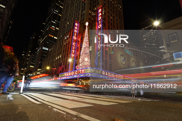 Car and foot traffic goes by Radio City Music Hall in New York, N.Y., on December 12, 2024. The photo is taken as a long exposure. 