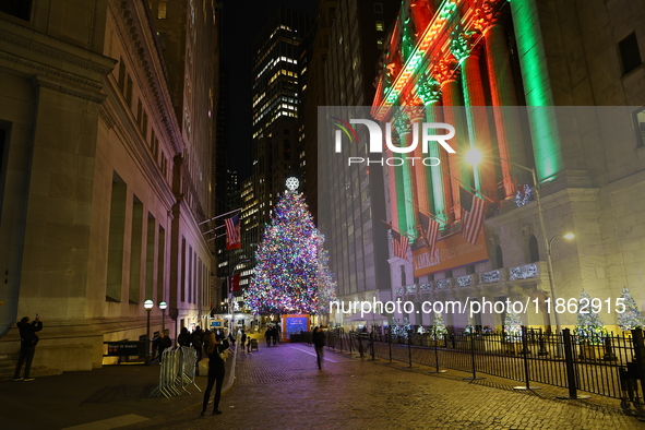 The Christmas tree on Broad Street and colored seasonal lights illuminate the New York Stock Exchange in New York, N.Y., on December 12, 202...