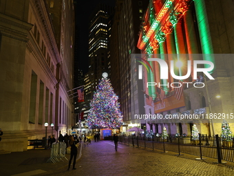 The Christmas tree on Broad Street and colored seasonal lights illuminate the New York Stock Exchange in New York, N.Y., on December 12, 202...