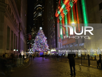 The Christmas tree on Broad Street and colored seasonal lights illuminate the New York Stock Exchange in New York, N.Y., on December 12, 202...