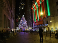 The Christmas tree on Broad Street and colored seasonal lights illuminate the New York Stock Exchange in New York, N.Y., on December 12, 202...