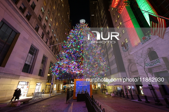 The Christmas tree on Broad Street and colored seasonal lights illuminate the New York Stock Exchange in New York, N.Y., on December 12, 202...