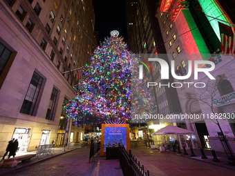 The Christmas tree on Broad Street and colored seasonal lights illuminate the New York Stock Exchange in New York, N.Y., on December 12, 202...