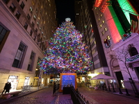 The Christmas tree on Broad Street and colored seasonal lights illuminate the New York Stock Exchange in New York, N.Y., on December 12, 202...