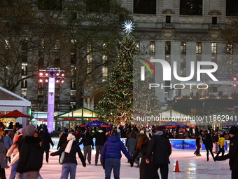 People skate in the Winter Village in Bryant Park in New York, N.Y., on December 12, 2024. The photo is taken as a long exposure. (