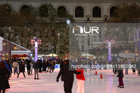 People skate in the Winter Village in Bryant Park in New York, N.Y., on December 12, 2024. The photo is taken as a long exposure. 