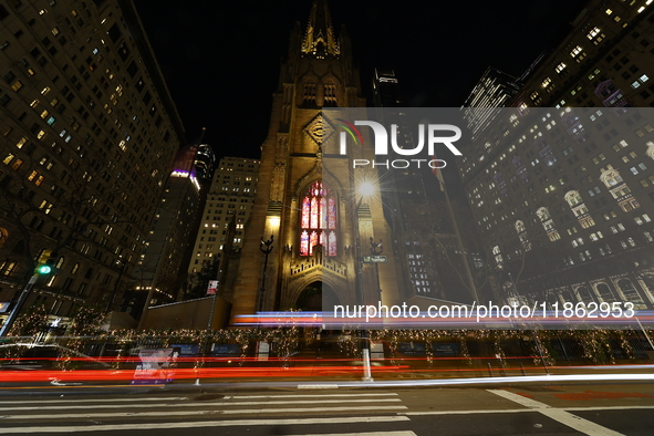 Traffic and pedestrians make their way along Broadway past Trinity Church in New York, N.Y., on December 12, 2024. 